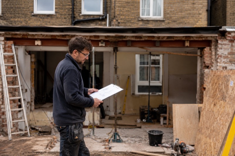 A builder reviewing plans on site